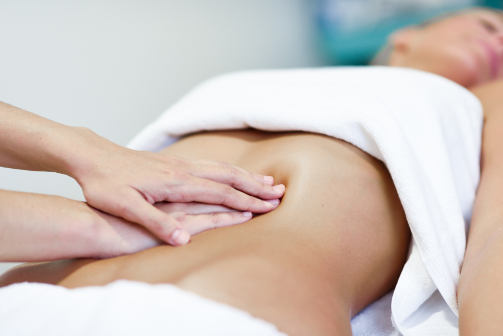 Viszerale Therapie in Fürth: sanfte Behandlung am Bauch einer liegenden Patientin